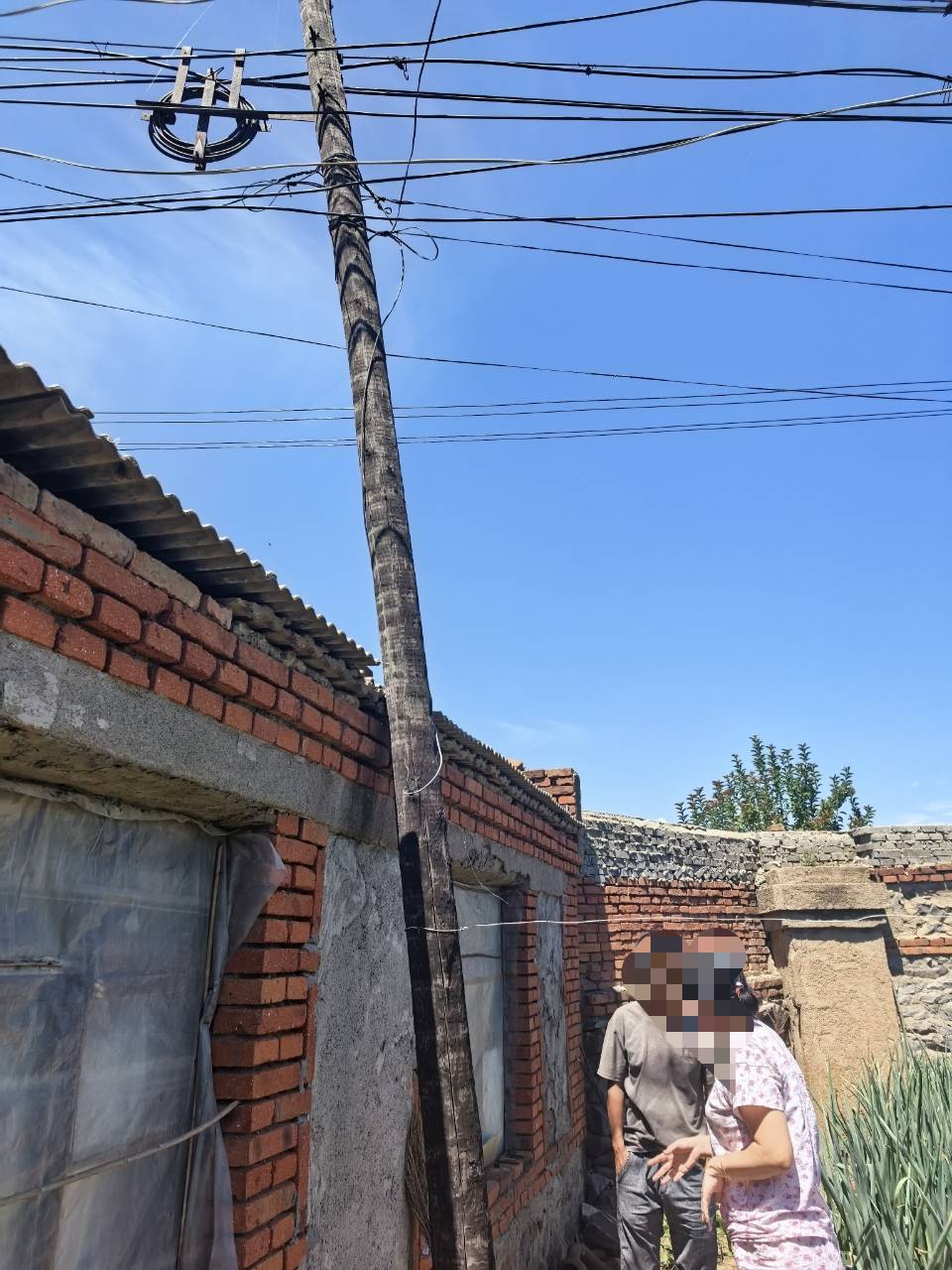 辽宁锦州一电信电线杆设在居民院子里拒绝移走？电信公司：已与当事人协商一致